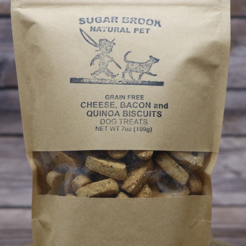 Close-up of Sugar Brook Cheese, Bacon, and Quinoa Biscuits Dog Treats in a kraft paper bag with a window, highlighting the artisanal treats