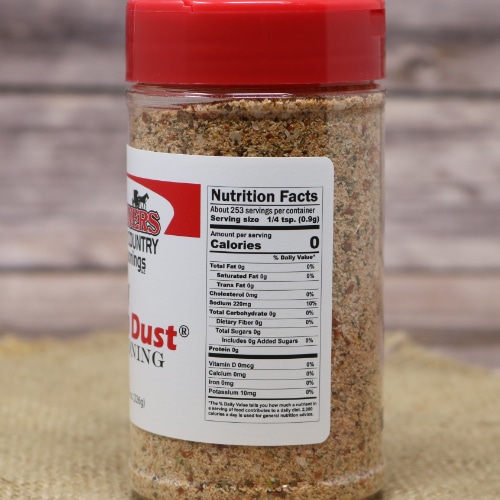 Nutritional facts label on the side of a Weaver's Spicy Farm Dust Seasoning bottle with a red lid, against a burlap backdrop.