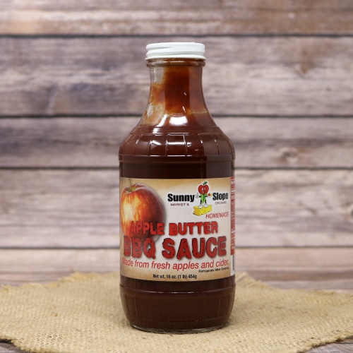 A bottle of Sunny Slope Apple Butter BBQ Sauce with a white lid.