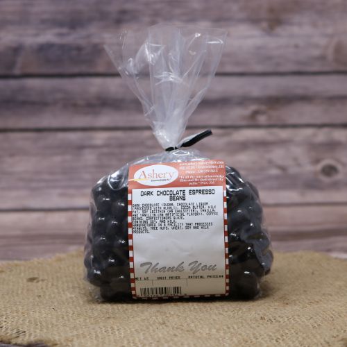 Clear plastic Ashery bag with red and white sticker label filled with dark chocolate espresso beans, sitting on a burlap material with wood background