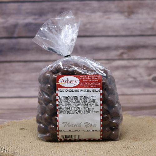 Clear plastic Ashery bag with red and white sticker label filled with chocolate candies, sitting on a burlap material with wood background