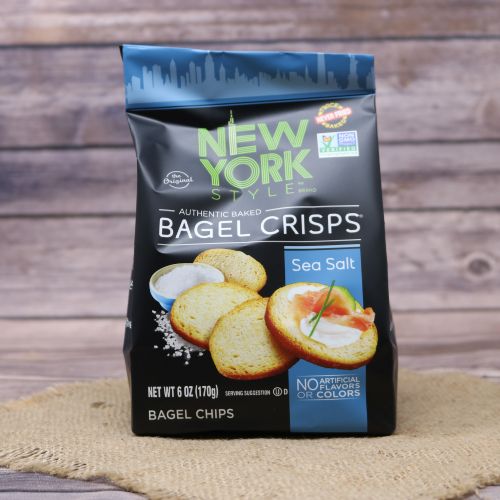Black plastic bag with blue accents and a picture of New York style bagel crisps, sitting on a burlap material with wood background
