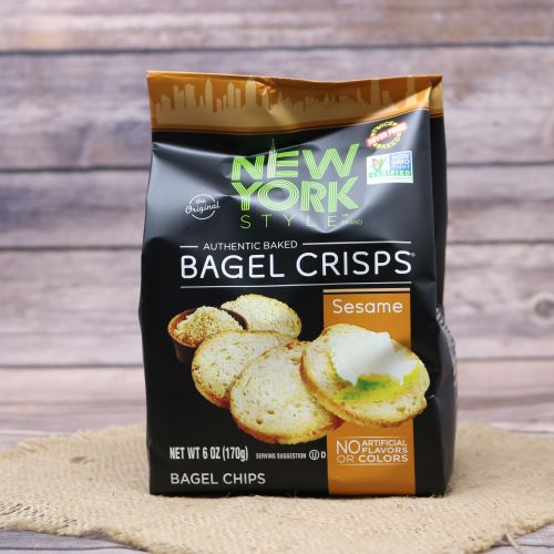 Black plastic bag with orange accents and a picture of New York style bagel crisps, sitting on a burlap material with wood background