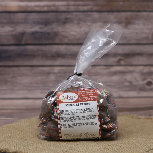 Clear plastic Ashery bag with red and white sticker label filled with chocolate candies, sitting on a burlap material with wood background