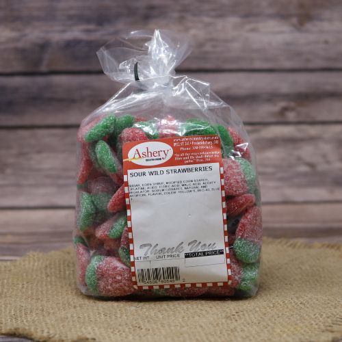 Clear plastic Ashery bag with red and white sticker label filled with red and green candies sitting on a burlap material with wood background