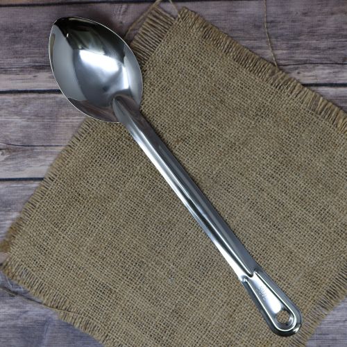 Stainless steel spoon sitting on a burlap material with wood background