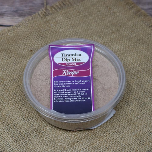 Clear plastic bowl with a red and purple sticker on a clear lid sitting on a burlap material