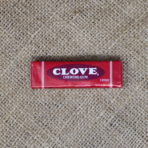 Pack of Clove chewing gum with five sticks, featuring a bold red wrapper with white text, on a burlap fabric background.