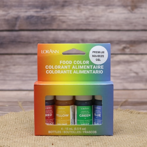 LorAnn Oils gel food coloring 4-pack with red, yellow, green, and blue dyes, presented on a straw mat against a wooden backdrop.