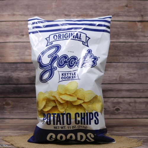 A classic white and blue bag of Good's Original Kettle Cooked Potato Chips standing upright on a straw mat with a wooden texture backdrop.