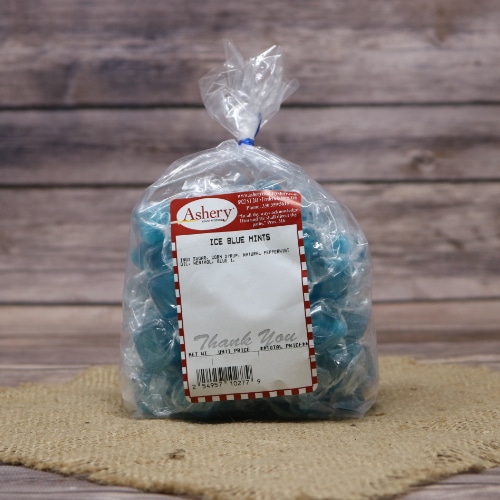 Clear plastic bag of Asher's Ice Blue Mints with a white and red label, placed on a burlap surface against a wooden backdrop.