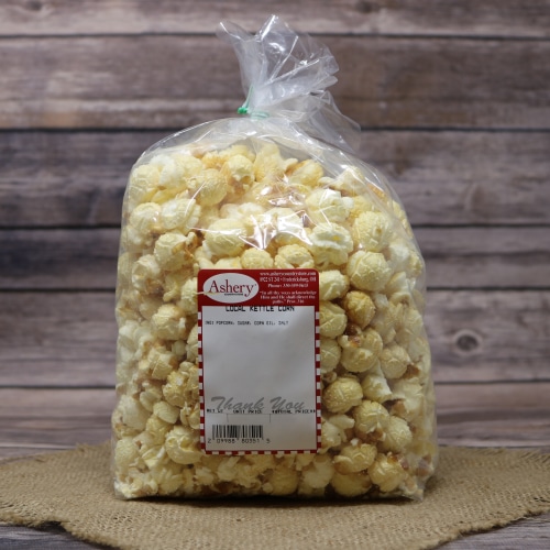 Bag of Ashery Local Kettle Corn on a burlap mat with a rustic wooden background.